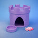 Purple 3D-printed castle tower accessory with an arched doorway, alongside a matching food bowl and a small pink brine shrimp figurine