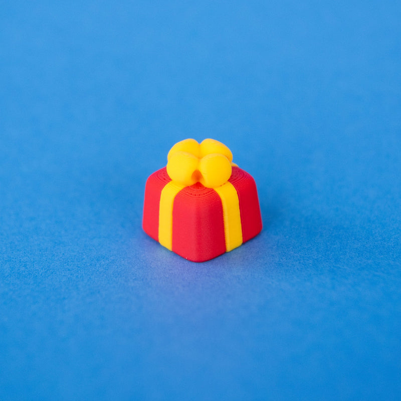 Bowsy the red present keycap with a yellow bow