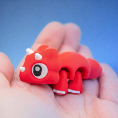 Close-up of Cera the triceratops fidget toy's face, showing its white horns and large eye