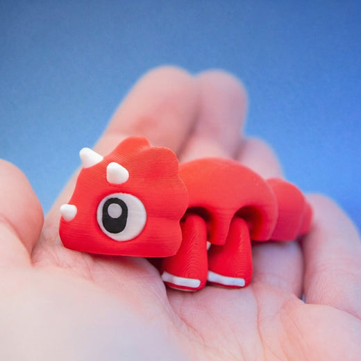 Close-up of Cera the triceratops fidget toy's face, showing its white horns and large eye