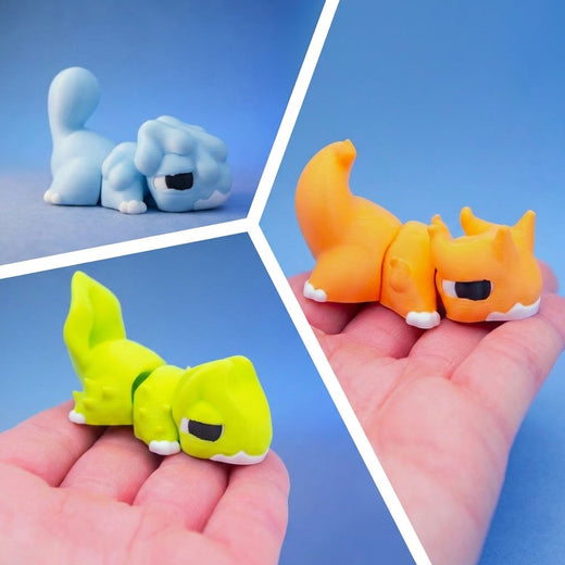 Three chonk dragon fidget toys grouped together - blue, yellow-green, and orange - resting in a hand