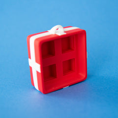 Empty red four-slot gift box clicker base, angled view