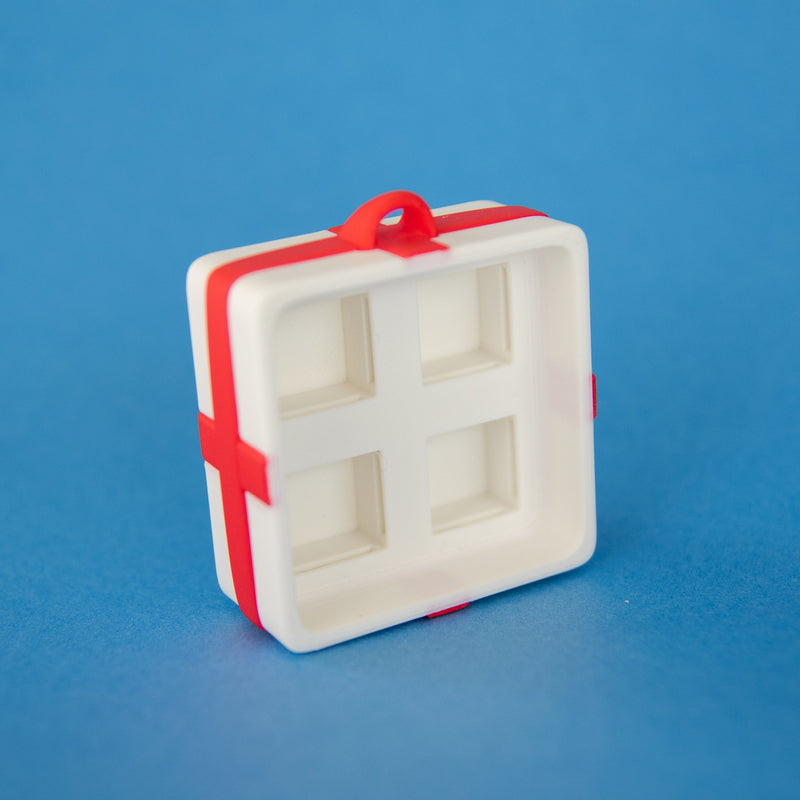 Empty white four-slot gift box clicker base, angled view
