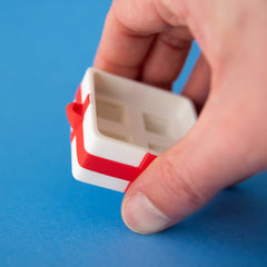 Empty white four-slot gift box base held in a hand