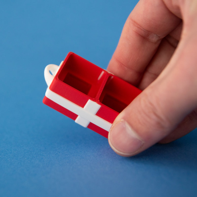 Red two-slot gift box base held between finger and thumb