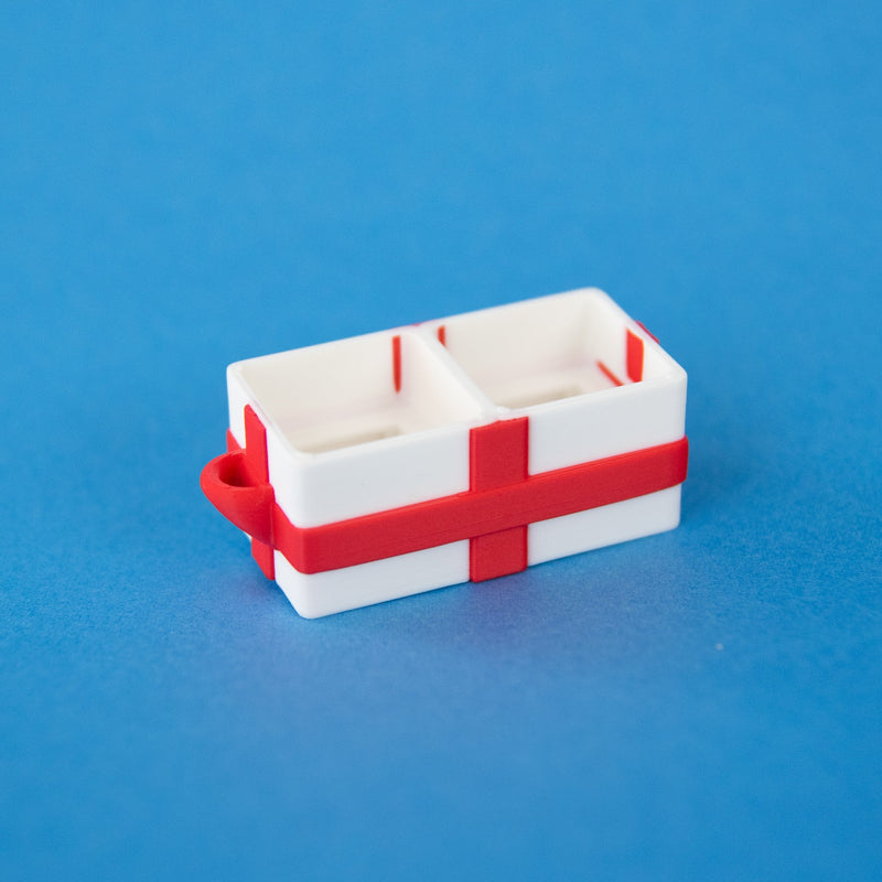 Empty white two-slot gift box clicker base with a red ribbon