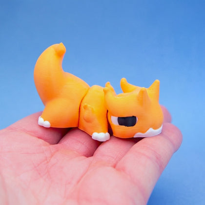 Orange chonk dragon fidget toy curled compactly in a hand