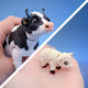 Black and white cow figurine and white sheep figurine shown together in a two-panel collage