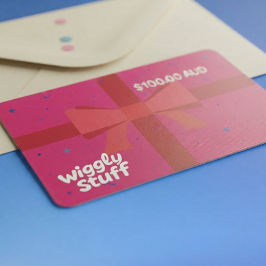 Pink Wiggly Stuff gift card showing a $100 AUD value, resting on its envelope