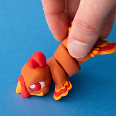 A hand lifting Gobb the Turkey Beastchonk to demonstrate his articulated body.