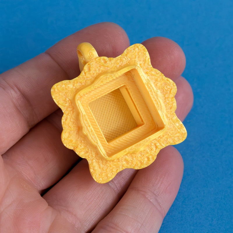 Gold frame keycap clicker empty in hand view.