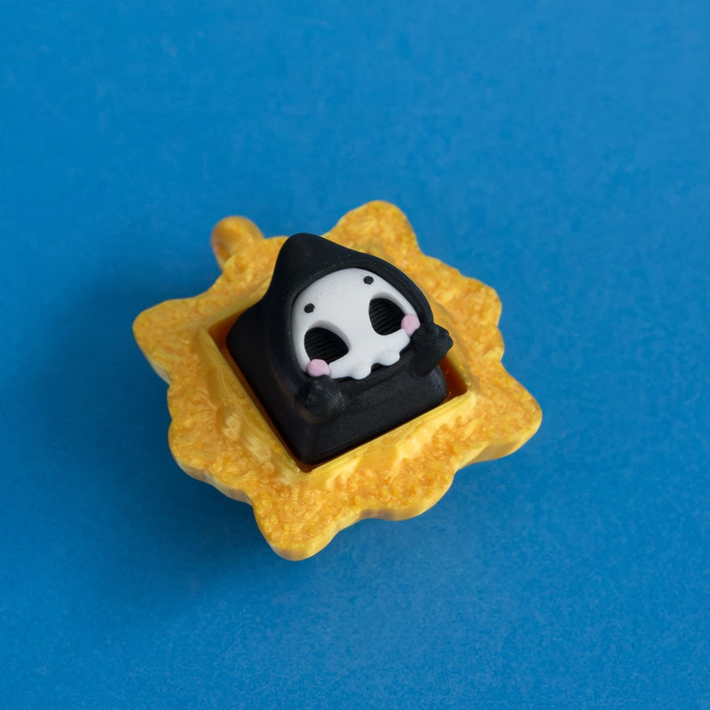 Grimsy the reaper keycap in gold frame clicker.