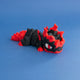 Gritt the Lava Chonk in a front three-quarter view, with cracked black scales, red flame details and a white eye with a red pupil.