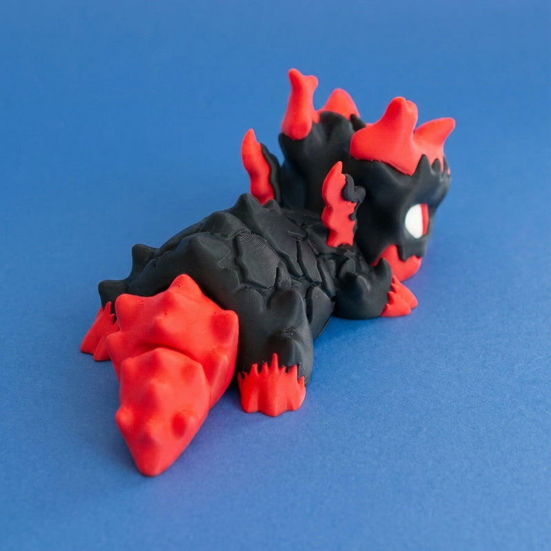 Rear three-quarter view of Gritt the Lava Chonk showing the red tail and cracked black body.