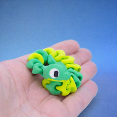 Green and yellow snake fidget toy coiled with its head lifted, looking up