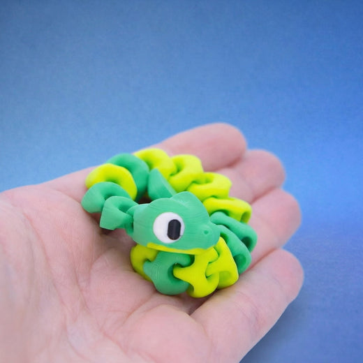 Green and yellow snake fidget toy coiled with its head lifted, looking up