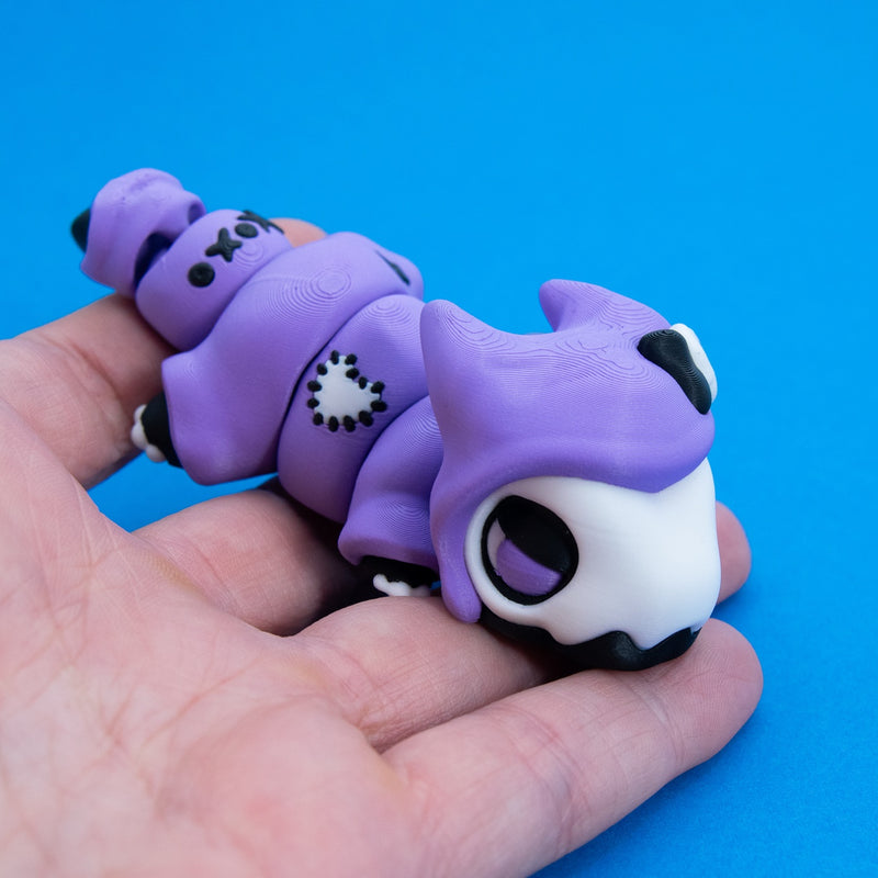 Kawaii Goth Reapo held in hand, showing the stitched heart patch on his cloak