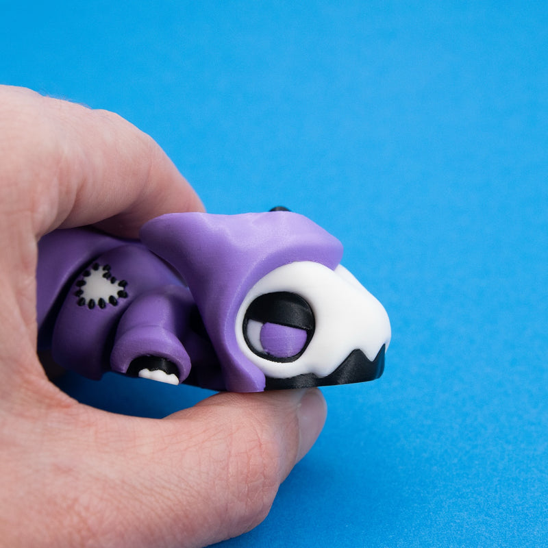 Close-up of Kawaii Goth Reapo's hood and sleepy eye held between fingers