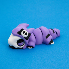 Kawaii Goth Reapo lying flat with his skull bow and stitched cloak, side view