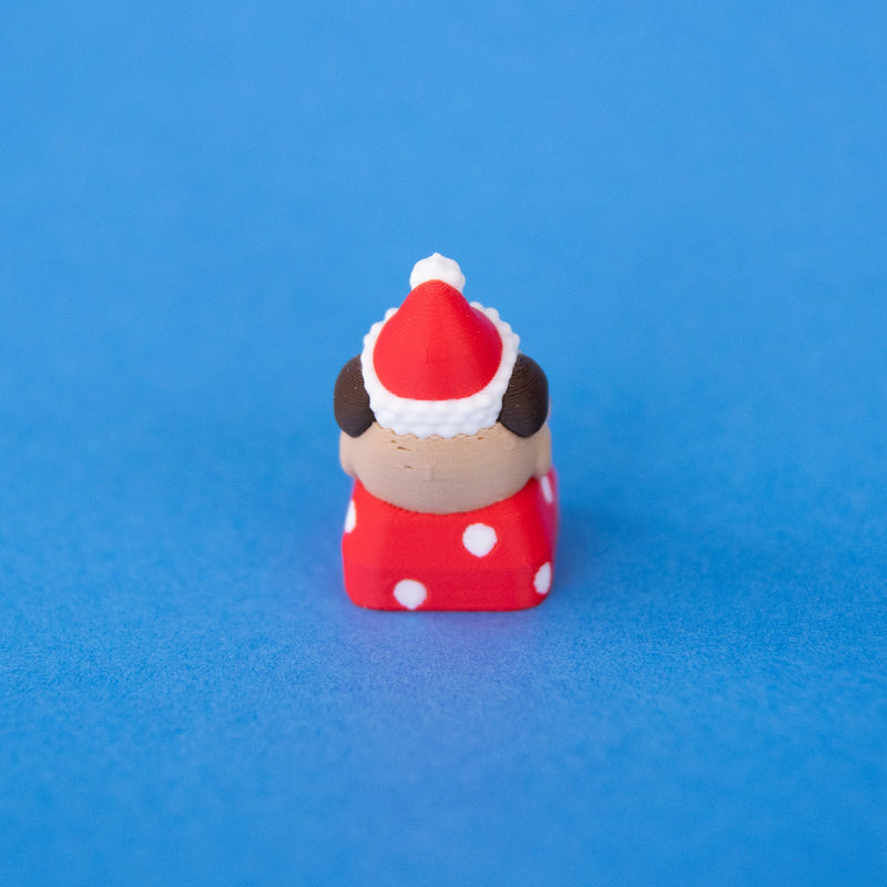 Nutmeg the Santa puppy keycap from behind, slightly angled