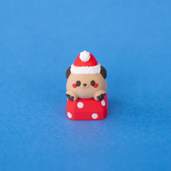 Nutmeg the Santa puppy keycap from a low front angle
