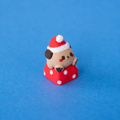 Nutmeg the Santa puppy keycap, three-quarter view from the right