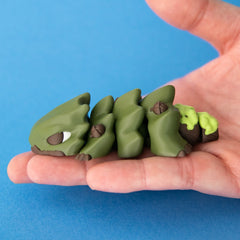 Oke the oak Chonk Dragon resting lengthways in an open palm to show his size.