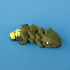 Opposite front view of Oke, showing his sleepy eye, leafy body segments and brown acorns.