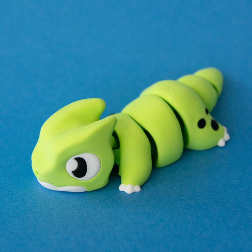 Three-quarter view of Orlo the Dino Beast Dragon facing left, with his articulated body and spotted shoulders visible.