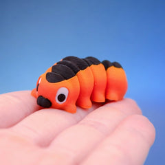Close-up of the orange caterpillar fidget toy's face and black stripe