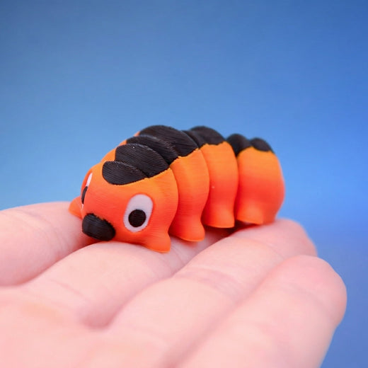 Close-up of the orange caterpillar fidget toy's face and black stripe