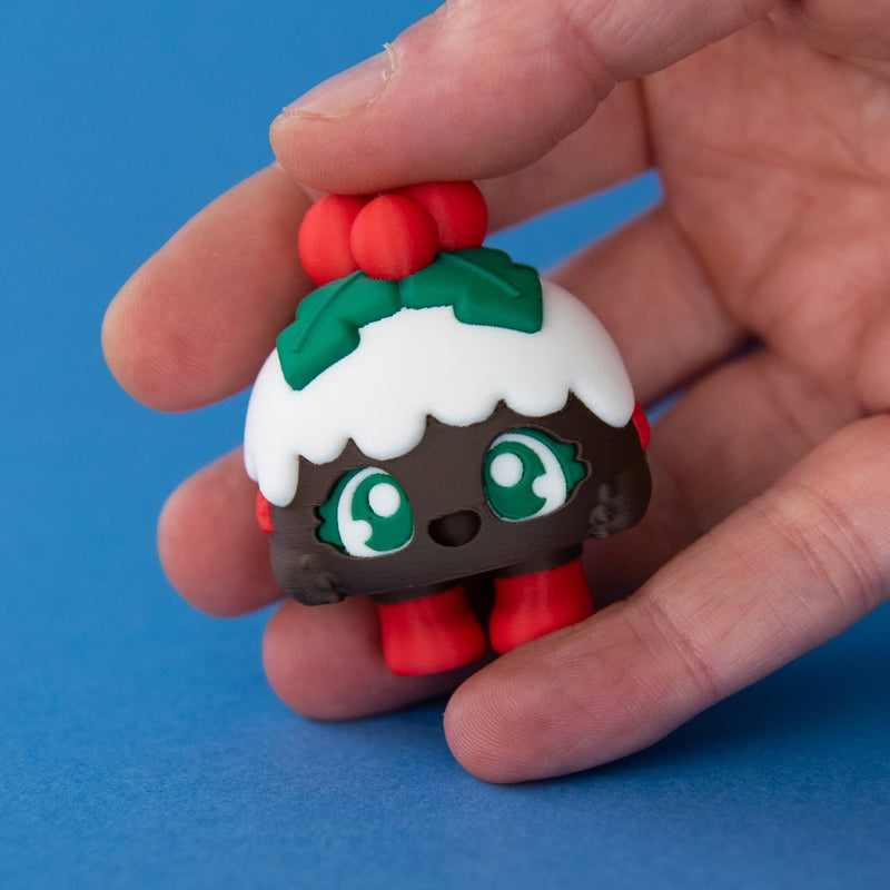 Plum the Christmas Pudding Clicker in hand on a blue background