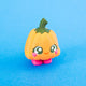 Posie the Pumpkin Clicker facing forward with orange pumpkin body, green stem and pink feet.