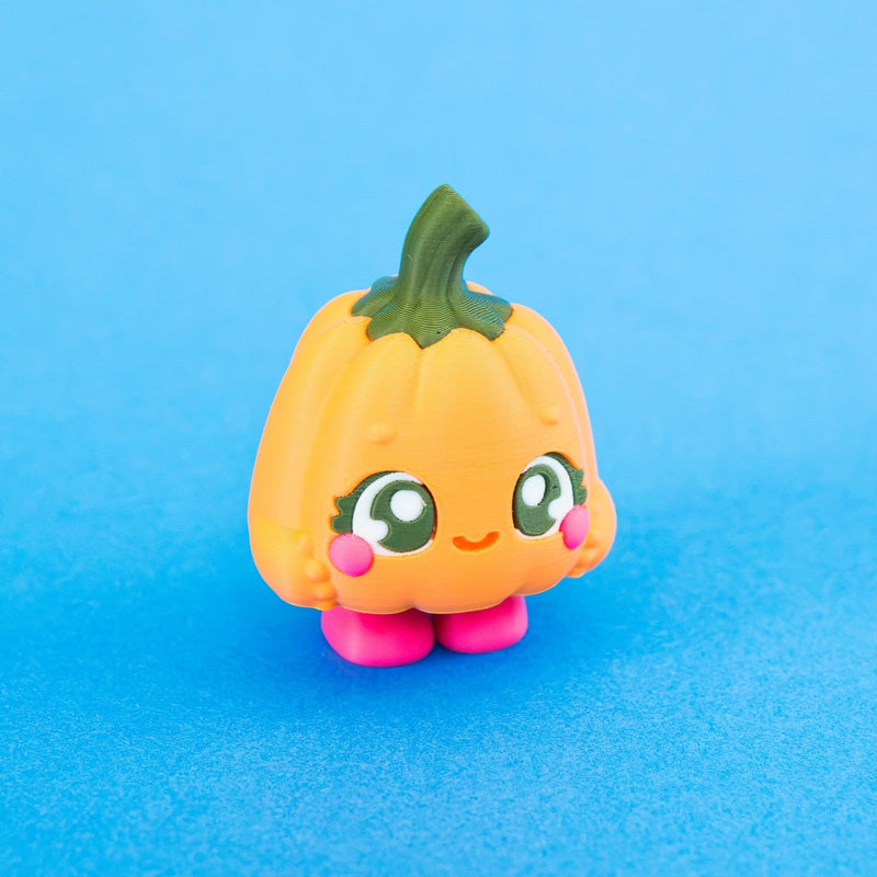 Posie the Pumpkin Clicker facing forward with orange pumpkin body, green stem and pink feet.
