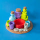 Potion Kit display set with bottles, cups, red mixing bowl and spoon on a wooden-look serving plate, front view