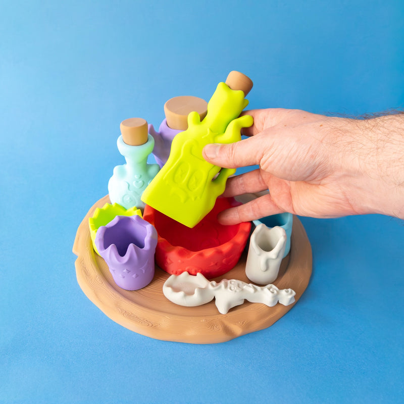 Hand tipping the green poison bottle over the mixing bowl