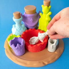 Hand stirring the Potion Kit spoon in the red mixing bowl