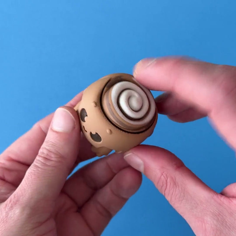 Roly the Cinnamon Roll Clicker 3D printed fidget wiggling in hand