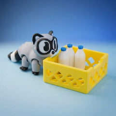 Grey and black raccoon figurine crawling toward a toy milk crate with bottles