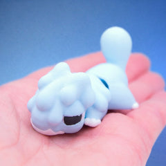 Pale blue chonk dragon fidget toy curled compactly in a hand