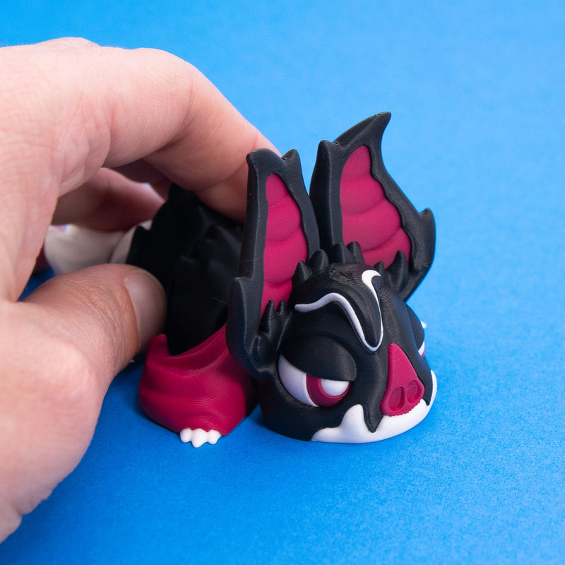 Fingers holding Sipp to show his tall bat ears up close