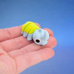 Sky-blue horned beetle fidget toy seen from behind, showing its neon-green shell