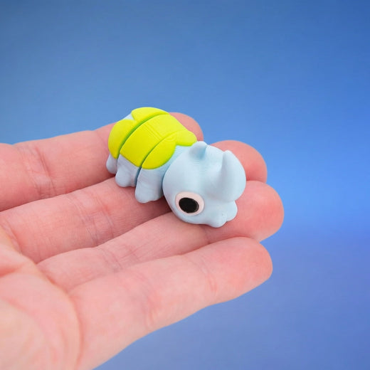 Sky-blue horned beetle fidget toy seen from behind, showing its neon-green shell