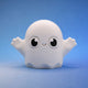 White ghost bean fidget figurine with round eyes and a cheeky grin, arms raised