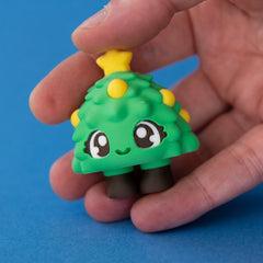 Tannen the Christmas Tree Clicker in hand pressed on a blue background
