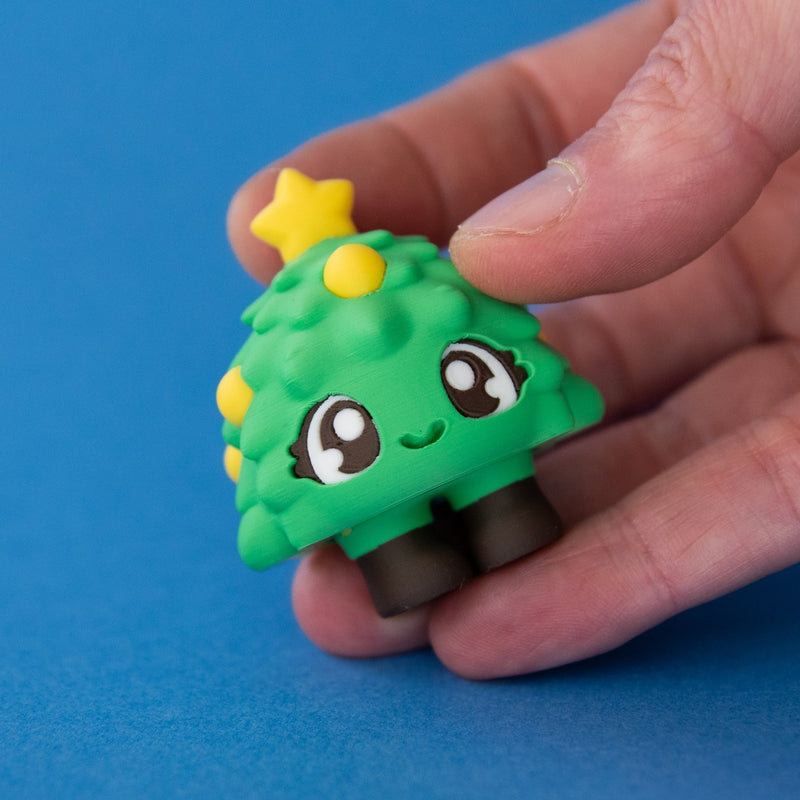 Tannen the Christmas Tree Clicker in hand released on a blue background