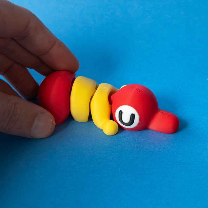 Trek in red and yellow, asleep, held by the tail